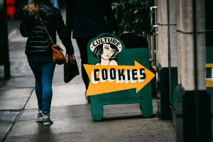 a woman walks past a sign advertising cookies